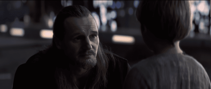 Qui-Gon Jinn kneels to talk to a young Anakin